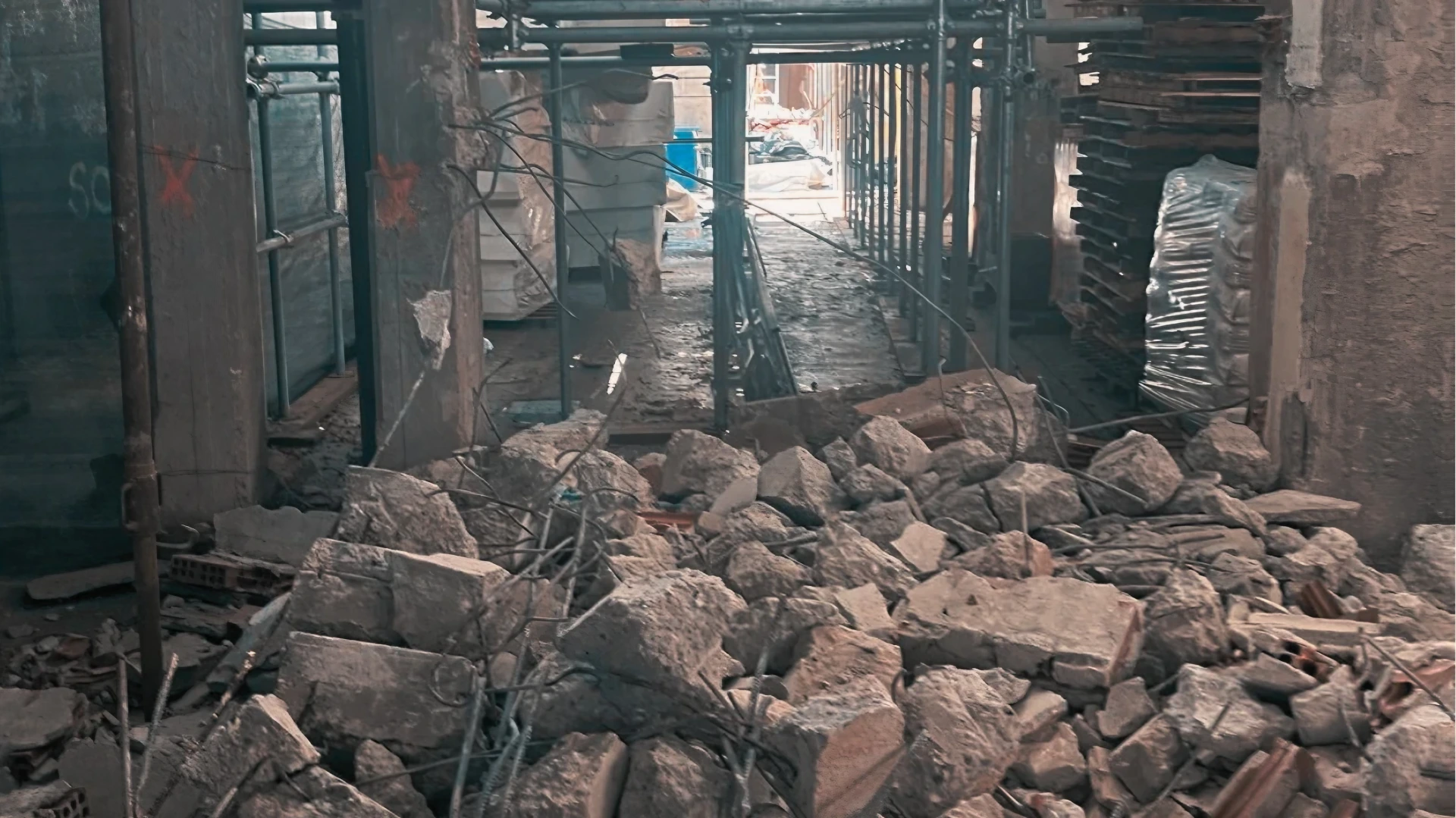Macerie, ferri d'armatura e ponteggi in cantiere dopo demolizione interna