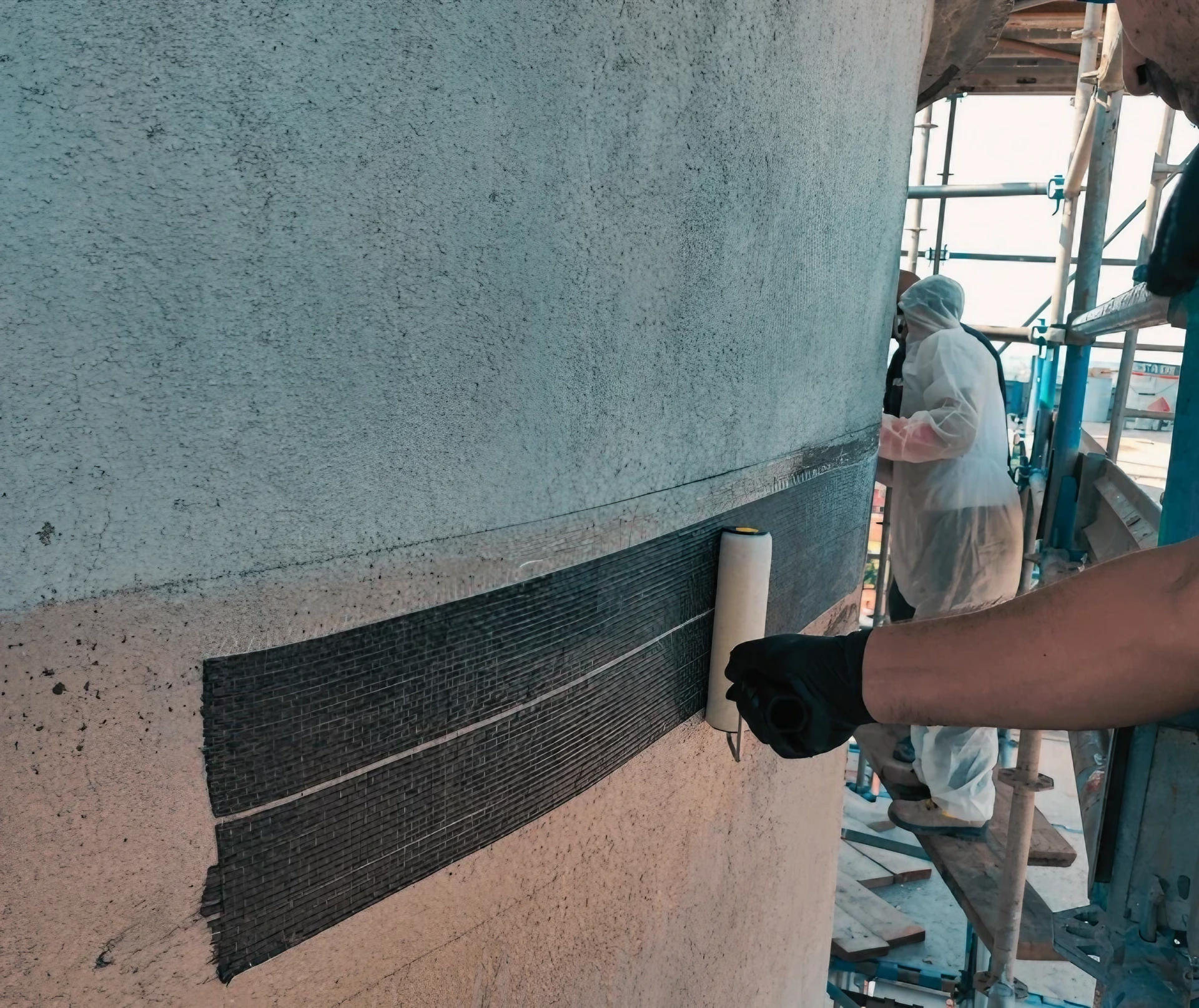 Applicazione rinforzo strutturale su colonna, cantiere edile